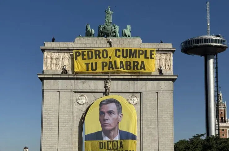 Activistas despliegan una pancarta en el arco de Moncloa tras el informe del CSN