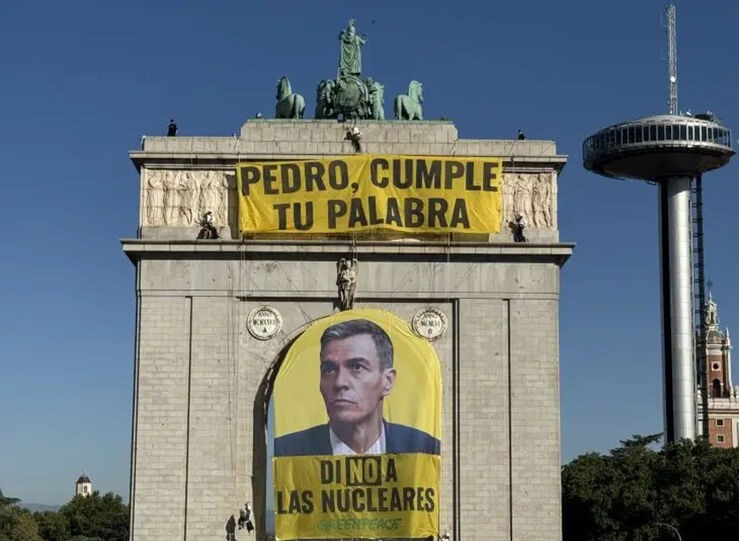 Activistas despliegan una pancarta en el arco de Moncloa tras el informe del CSN
